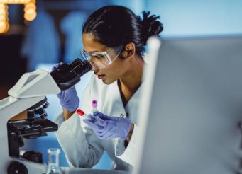 Young Scientist Looking Through a Microscope